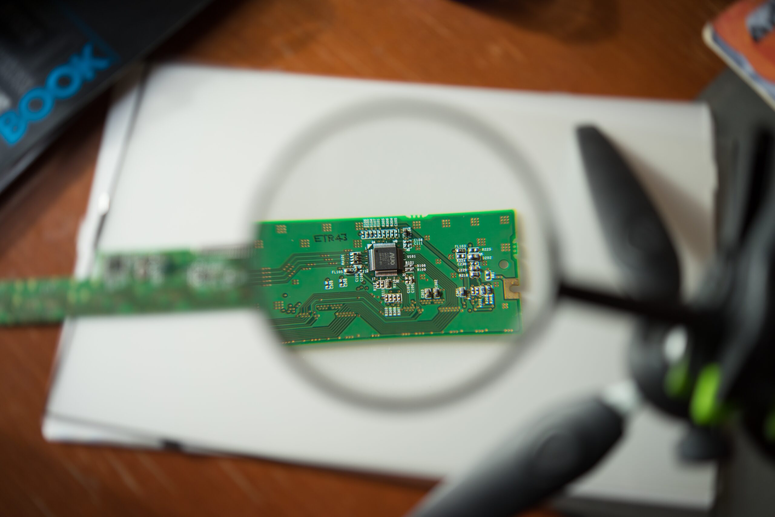 An engineer looking at a circuit board through a magnifying glass| website developments